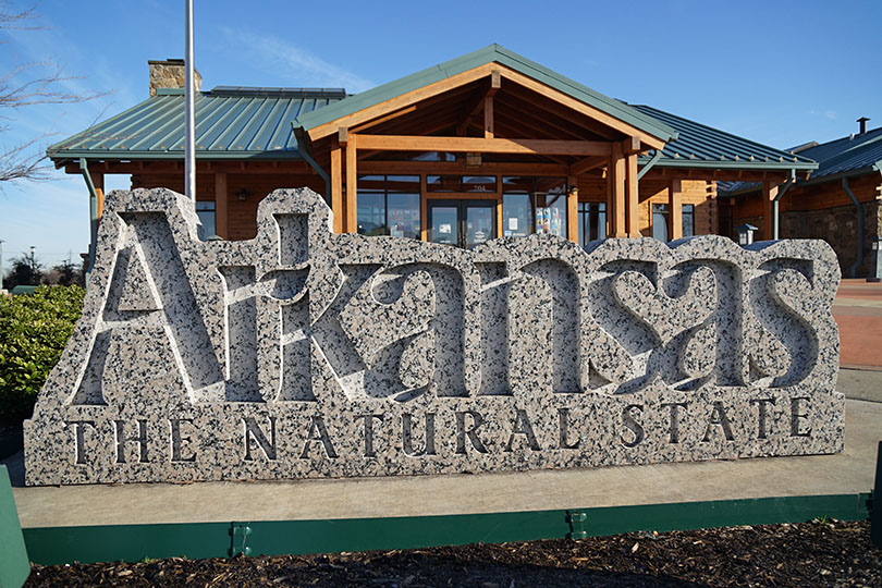 Arkansas Welcome Center with Granite Sign saying "Arkansas, the Natural State."