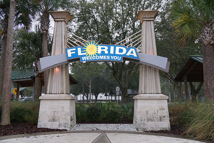Florida Welcomes You sign as seen from the rest area; stopping is prohibited on the highway.