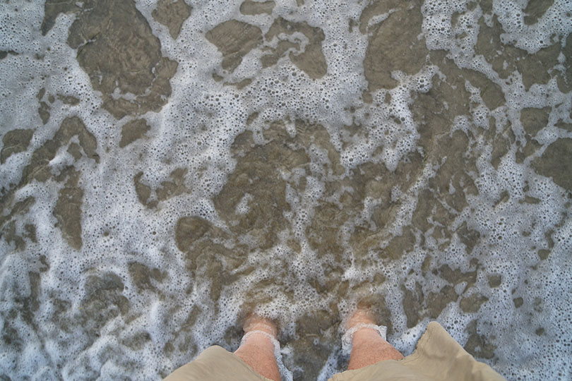 Ray's feet in the Pacific Ocean.