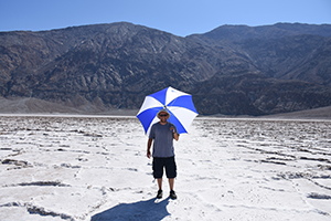 Ray shading himself with an umbrella in Badwater Basin in Death Valley National Park